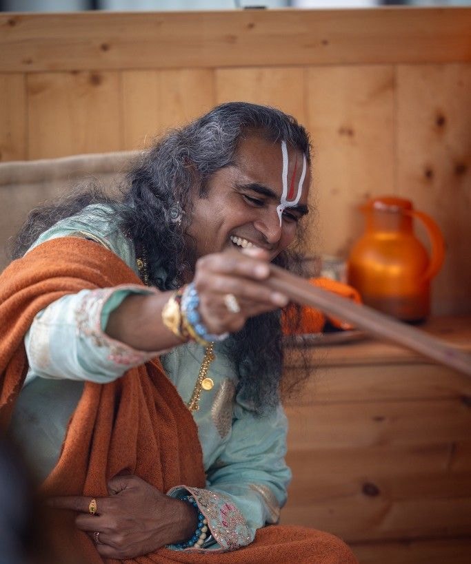 Swami with arms raised in crowd